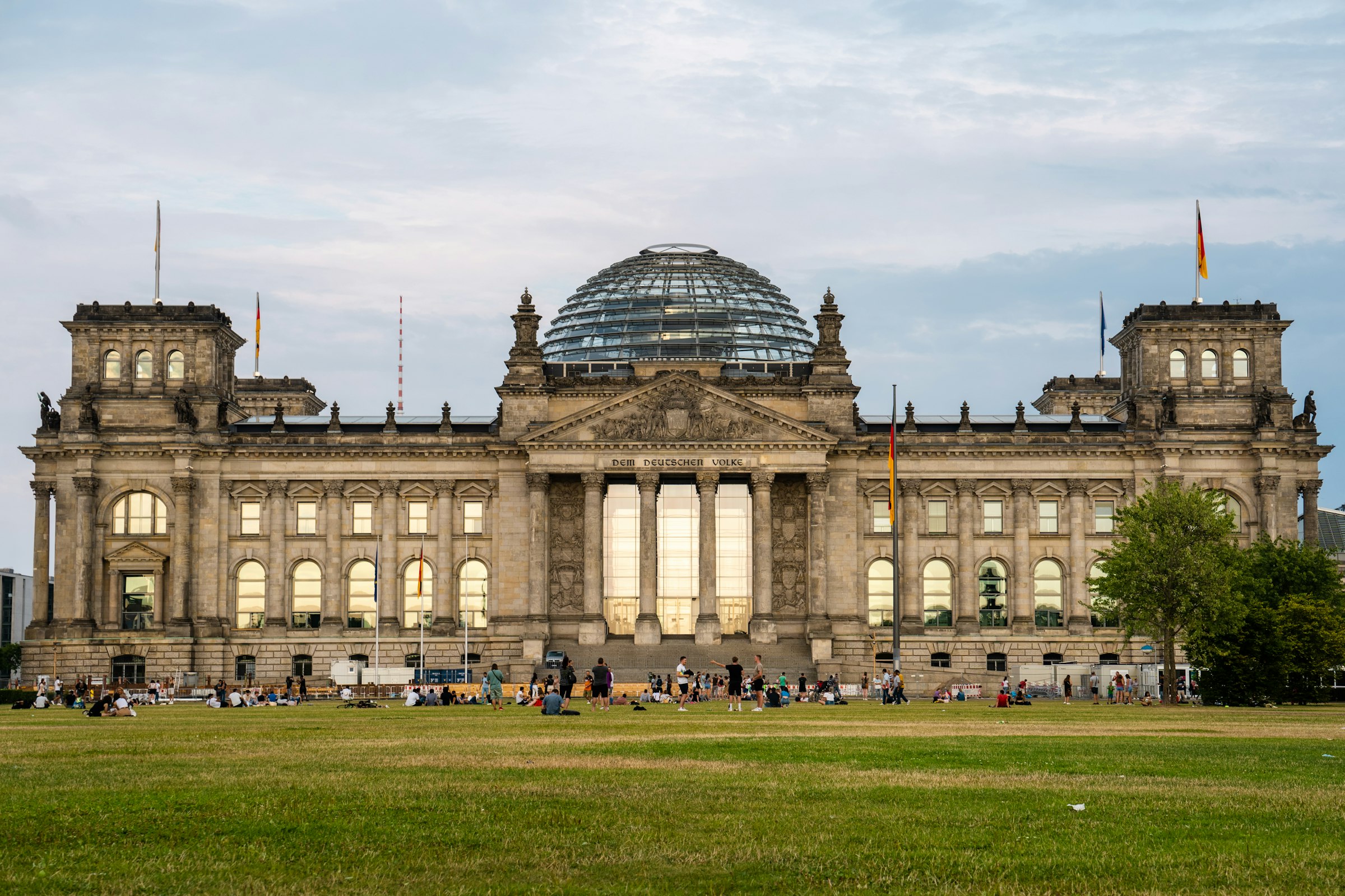 The Reichstag building seen across its lawn under a wide sky.