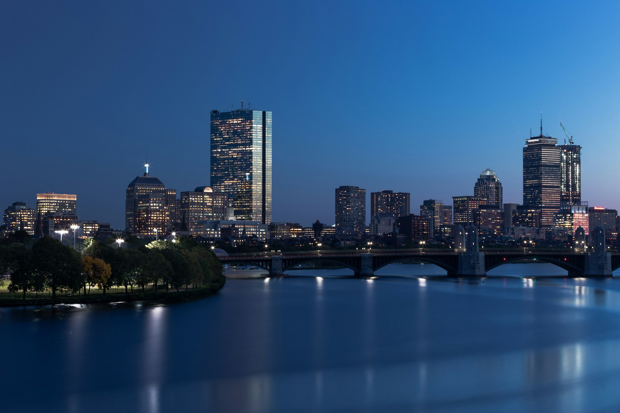 The Boston skyline reflected in the Charles River at night.
