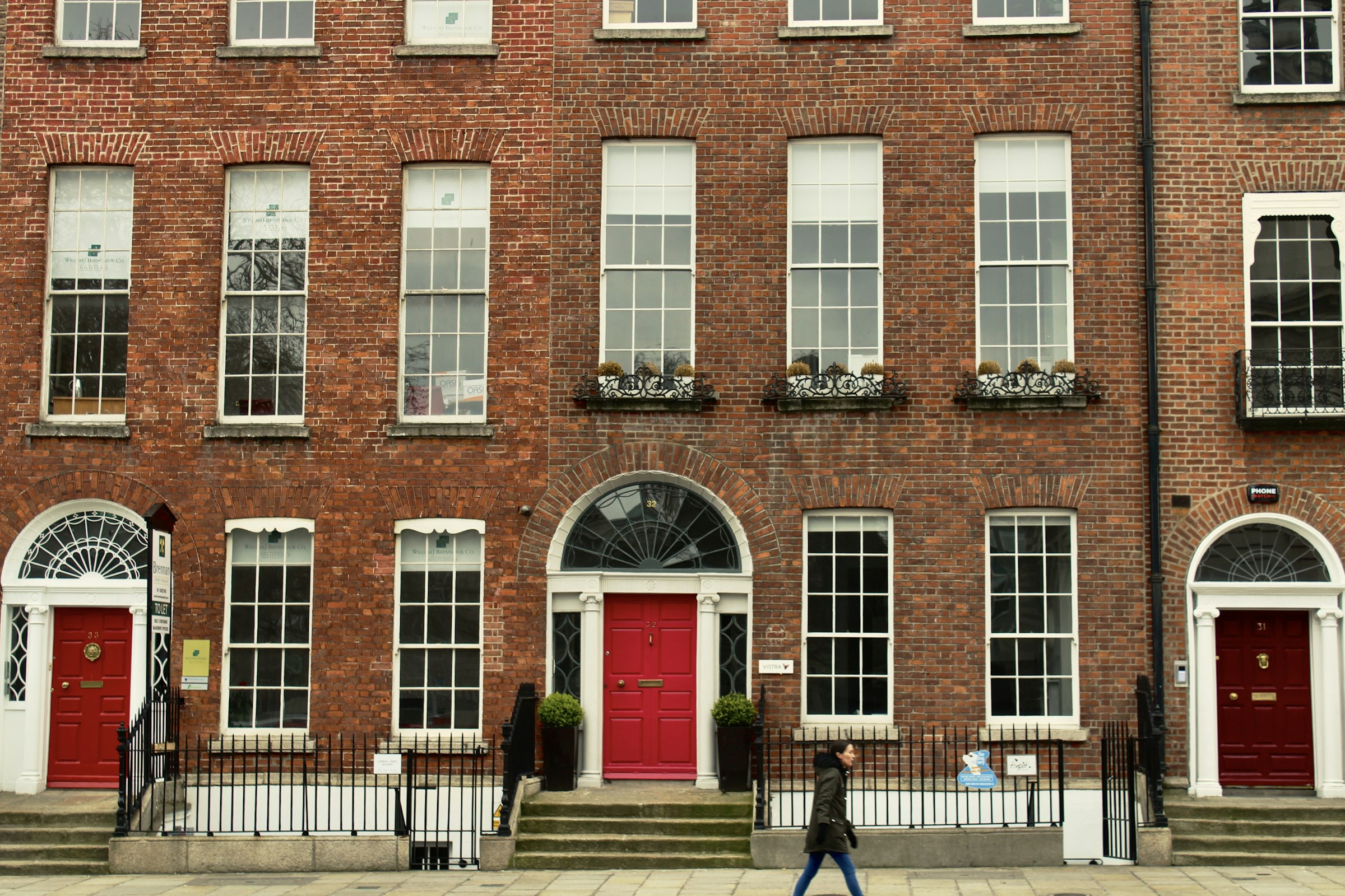 A red-brick Georgian terrace with painted front doors under fanlights.