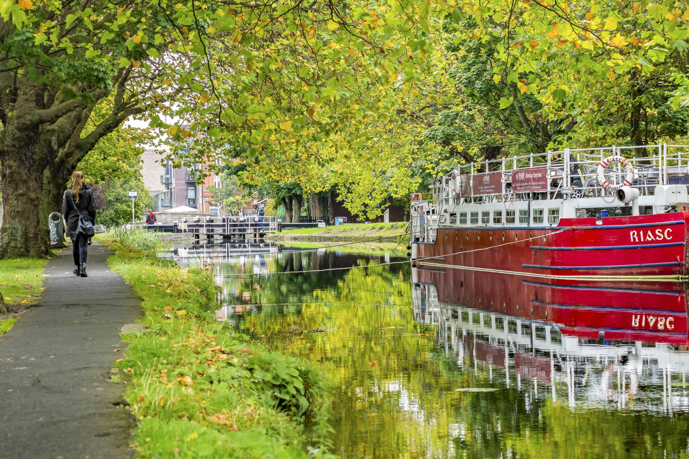 The Grand Canal in Dublin, a red boat moored under autumn trees.