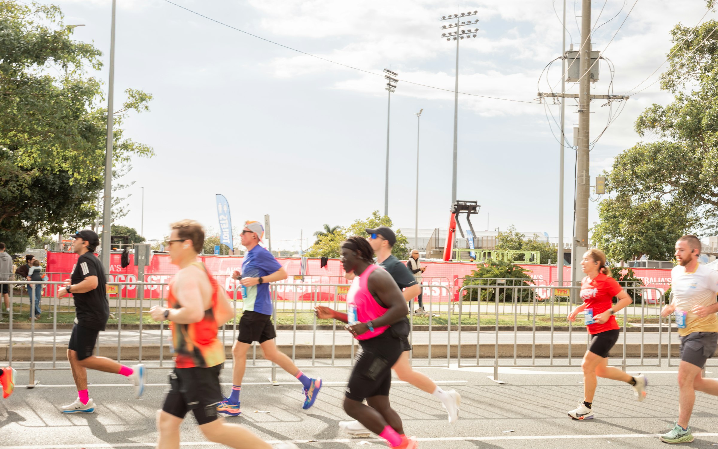 Runners on race weekend in July 2026, in vests and shorts. The half's mornings have a median of about 14 °C. Photograph: Joseph Prospere, Unsplash.