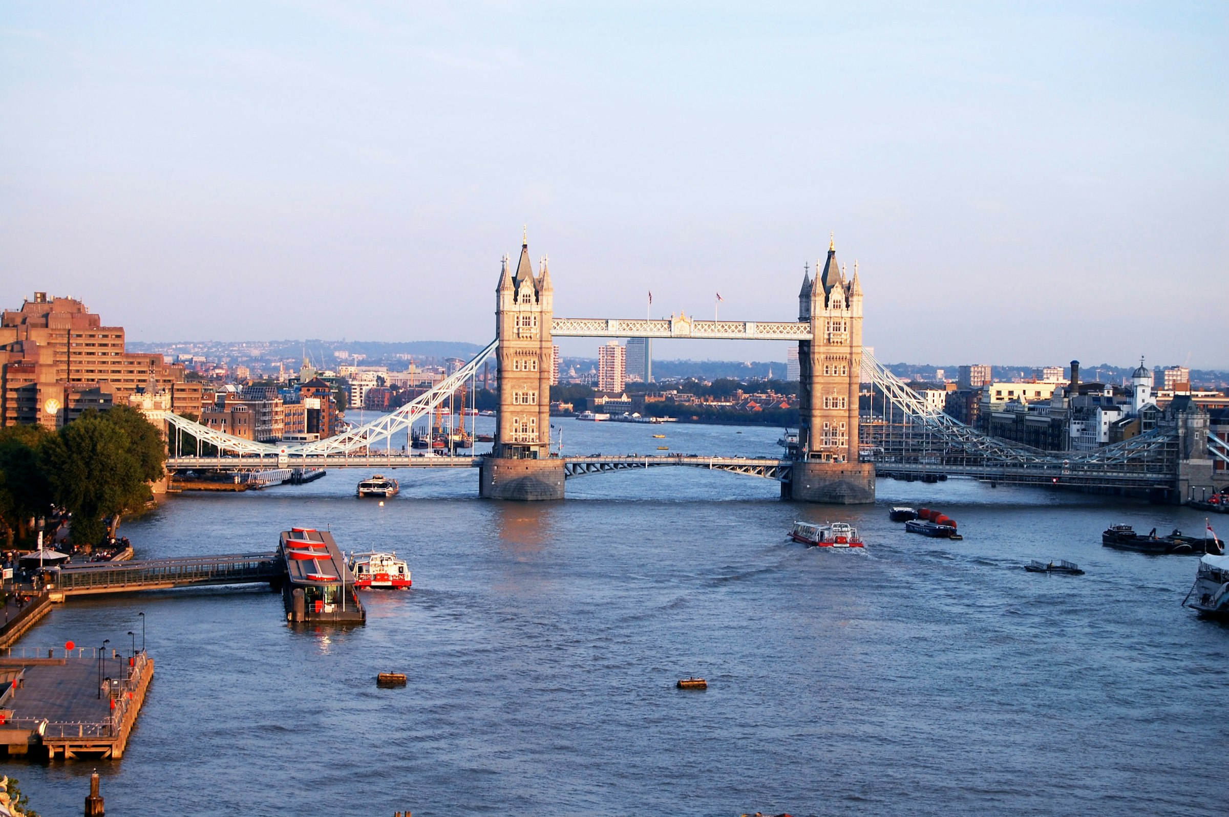 Tower Bridge seen from further up the River Thames, boats on the water in front of it.