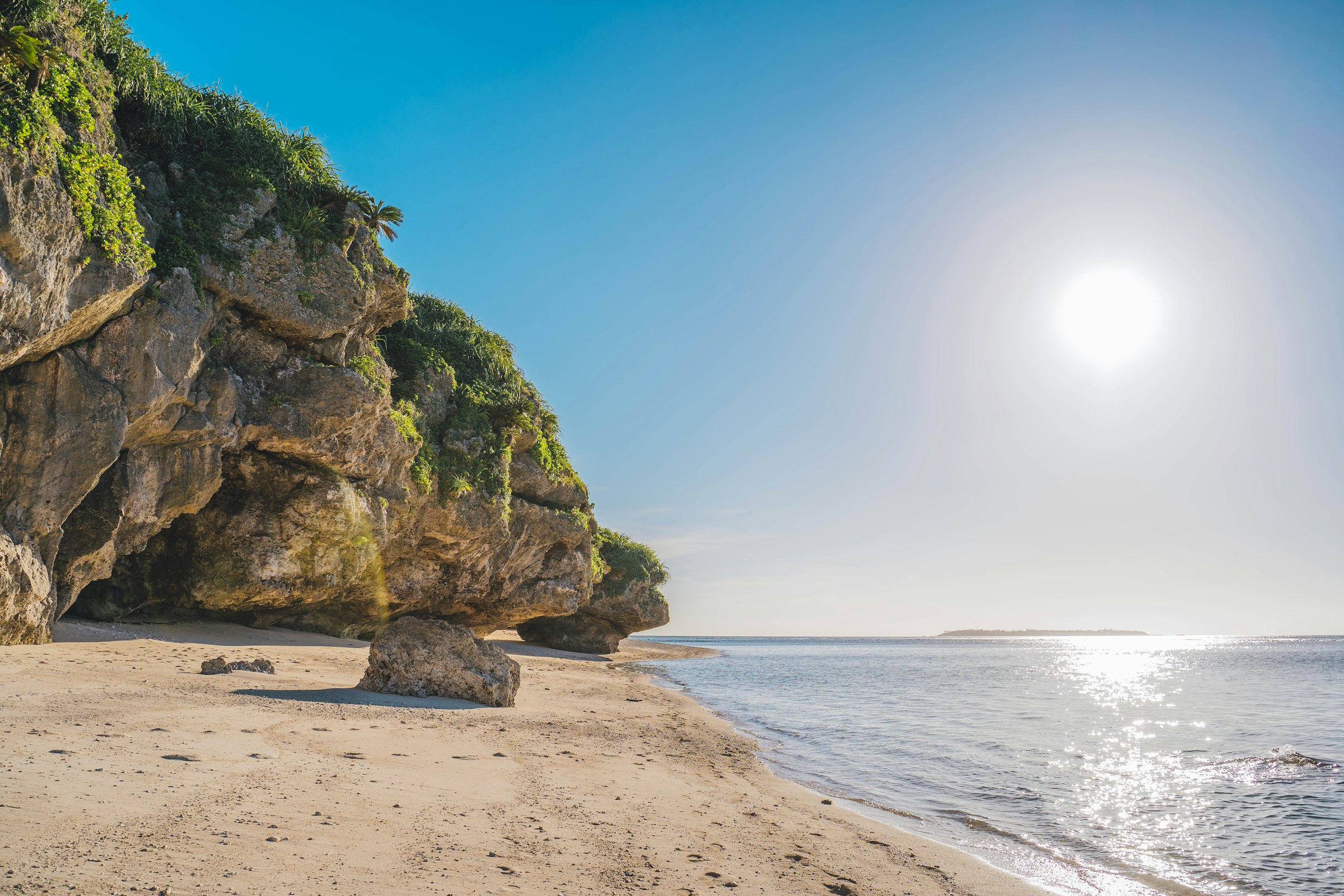 The coast of southern Okinawa. The Peace Memorial Park, at halfway, stands on the cliffs above it. Photograph: Roméo A., Unsplash.